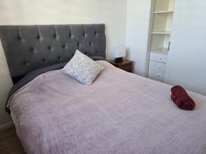 a bedroom with a large bed with a gray headboard at Familiar Departamento 3 dorm 2 baños in Rancagua