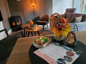 a living room with a table with a bowl of food at Secret Wellness Puur Natuur in Holten +14 photos