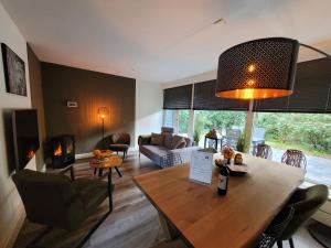 a living room with a table and a living room with a fireplace at Secret Wellness Puur Natuur in Holten