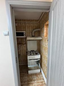 a small kitchen with a stove and a microwave at 2 rooms apartment Craiova-Craiovita Noua in Craiova +10 photos