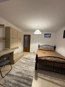 a bedroom with a bed and a desk and a desk at 2 rooms apartment Craiova-Craiovita Noua in Craiova