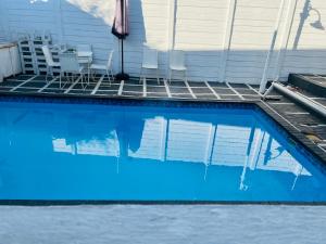 a swimming pool with chairs and a house at Mekenificent Stays in Windhoek