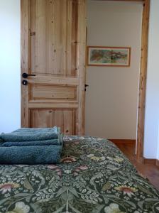 a bedroom with a bed and a wooden door at NEW - Jardin - Proche Briançon Serre Che - Vue montagne - Ski in Villar-Saint-Pancrace