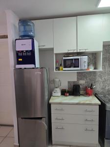 a kitchen with a refrigerator and a microwave at Familiar Departamento 3 dorm 2 baños in Rancagua