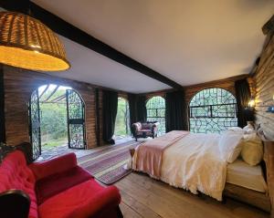 a bedroom with a bed and a couch and windows at TheCabinsNanyuki in Nanyuki +216 photos