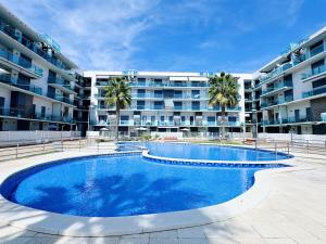 a large swimming pool in front of a large apartment building at Harmony by the Sea in Cambrils