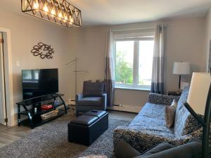 a living room with a couch and a tv at Mariners Nest in Saint John