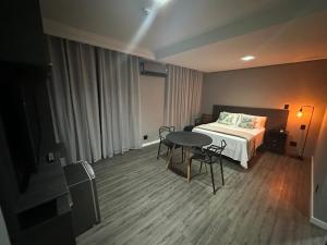 a bedroom with a bed and a table and chairs at Manaus Hotéis Millenium - Flat 804 in Manaus +14 photos