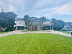 una casa con un gran césped delante de ella en Pets welcome in a spacious 1 bedroom with a fenced in backyard and treadmill, en Cedar Point