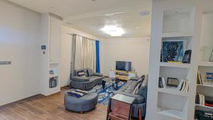 a living room with two couches and a tv at Le Champ des Roseaux - Kotto Douala in Douala