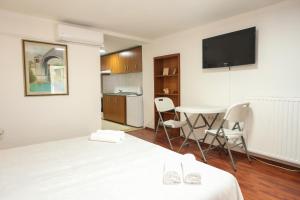 Habitación con cama y mesa con sillas. en Apartment Pajevic, en Mostar