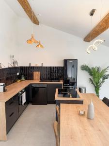 cocina con electrodomésticos negros y mesa de madera en Cinema Loft, en Elne