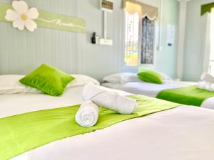 a room with three beds with towels on them at Caca Kabin in Mersing