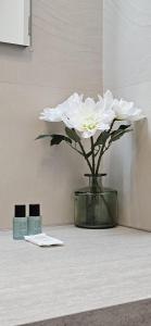 La Girelle - Clim - Balcon - Parking - Mer à 200m في كاري-لو-رويه: مزهرية مع زهرة بيضاء على طاولة +16 صورة