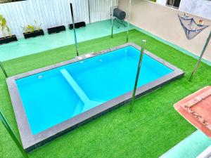 an empty swimming pool in a yard with grass at Caca Kabin in Mersing