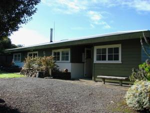 a green house with a bench in front of it at Tranquility Base - Coromandel in Tuateawa