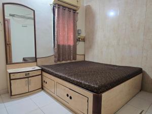 a small bathroom with a bed and a mirror at Mumbai Properties in Mumbai