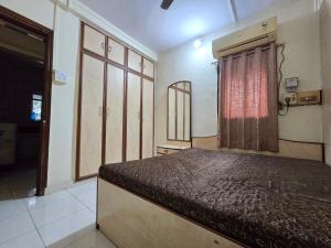 a bedroom with a bed and a window at Mumbai Properties in Mumbai