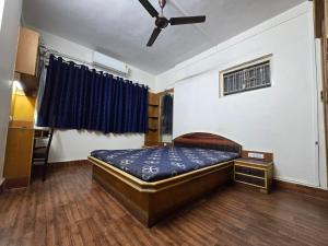 a bedroom with a bed and a ceiling fan at Mumbai Properties in Mumbai