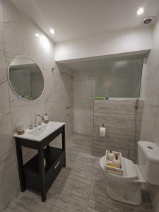 a bathroom with a sink and a toilet and a mirror at PH familiar en La Perla ideal para relax y turismo in Mar del Plata