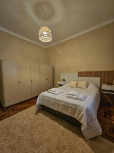 a bedroom with a large bed and a chandelier at PH familiar en La Perla ideal para relax y turismo in Mar del Plata