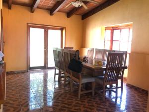 a dining room with a table and chairs and windows at Villa Familiar para descanso y convivios fin de semana in Nepantla de Sor Juana Inés de la Cruz