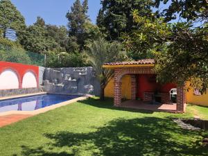 a backyard with a swimming pool and a house at Villa Familiar para descanso y convivios fin de semana in Nepantla de Sor Juana Inés de la Cruz