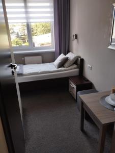 a small room with a bed and a window at Apart Iwona 209-210 in Koszalin +13 photos