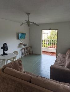 una sala de estar con un sofá y una mesa en Apartamento Prainha perto de tudo pe na areia - 3 andar escada, en Caraguatatuba
