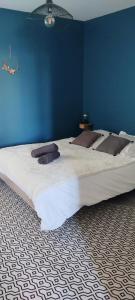 a large bed in a bedroom with a blue wall at MOINES - Centre historique de charme in Vannes