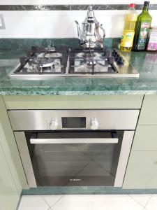 a stove top oven with a tea pot on top at Grand Appartement Idéal - Plein Coeur de Kénitra in Kenitra