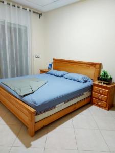 a bedroom with a wooden bed and a wooden dresser at Grand Appartement Idéal - Plein Coeur de Kénitra in Kenitra