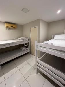 a room with two bunk beds and a bath tub at Pousada Aconxego in Fortaleza