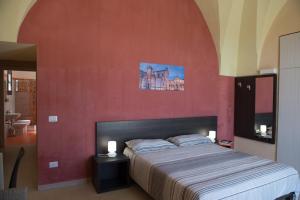 sypialnia z dużym łóżkiem z czerwoną ścianą w obiekcie Lu Panaru w mieście Lecce