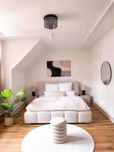 une chambre blanche avec un grand lit et une table dans l'établissement HAVN - Exklusive Maisonette im Herzen der Altstadt, à Bâle