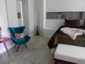 マラゴージにあるCasa jardinsのベッドルーム1室(ベッド1台、青い椅子付)