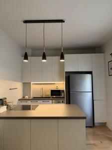 a kitchen with a refrigerator and a counter top at 2 Bedroom 2 Bath Modern Apartment in Athens