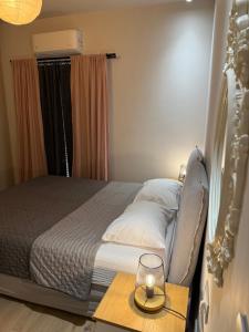a bedroom with a bed with a candle on a table at 2 Bedroom 2 Bath Modern Apartment in Athens