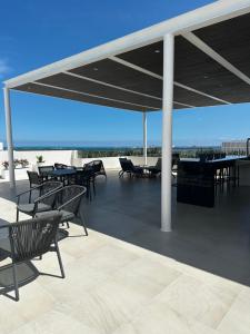 a patio with tables and chairs on a roof at Vela Towers in Cancún