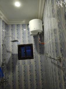a bathroom with a shower with a bucket on the wall at APART APARTMENTs in Brusubi +10 photos