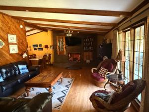 a living room with leather furniture and a table at The Downer House in Chattanooga
