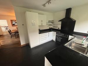 a kitchen with white cabinets and a black counter top at Pet Friendly House with Hot tub in Hale in Moffat