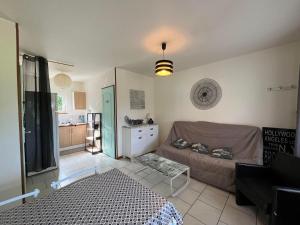 a living room with a couch and a kitchen at Gite Caillebourg Normandie in Saint-Martin-aux-Arbres