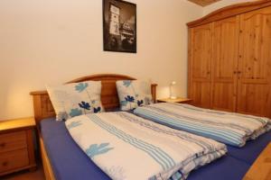 a bedroom with a bed with blue and white sheets at Ferienwohnung Rose auf Hof Stallegg in Löffingen