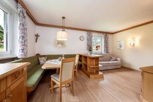 a living room with a green couch and a table at Reitsamerhof - Zimmer & Apartments in Werfen +48 photos