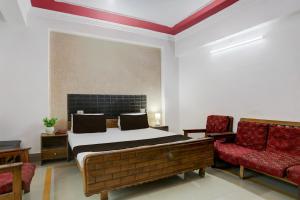 Un dormitorio con una cama y una silla roja. en Hotel O Welcome Palace, en Patna