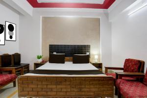 Un dormitorio con una cama de ladrillo y dos sillas. en Hotel O Welcome Palace, en Patna