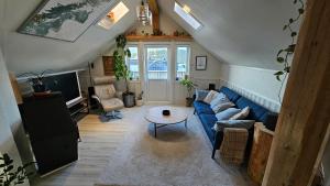 un soggiorno con un divano blu e un tavolo di Large room, unique loftspartment, balcony, free parking ad Ålesund