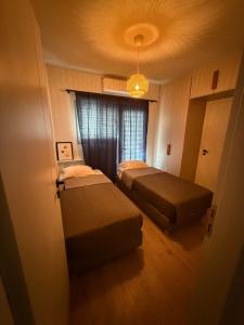 a small room with two beds and a window at 2 Bedroom 2 Bath Modern Apartment in Athens