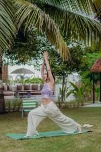 a woman doing a yoga pose on a yoga mat at Lush Life - Private Bali-Inspired Villa in Kanāria